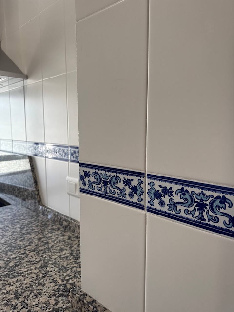 Cocina oscura con cenefa en azul conr elieve