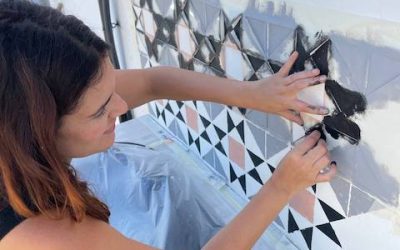 Gema pintando el zócalo de la cocina de exterior con esponja