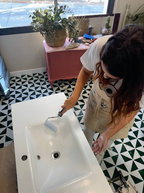 Gema pintando el lavabo con rodillo