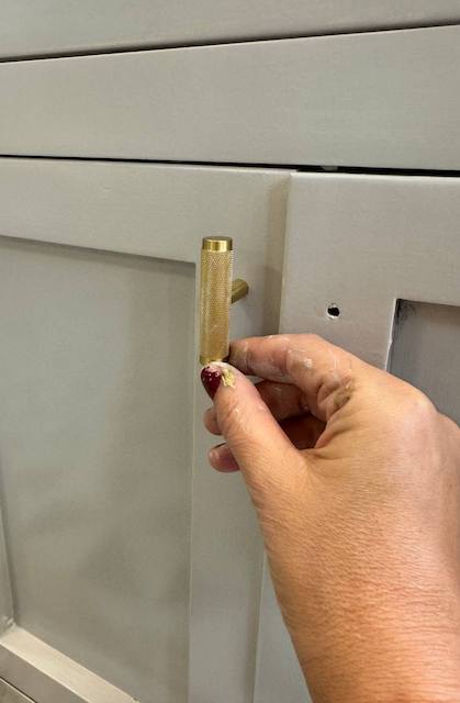 Colocamos los tiradores en el mueble del lavabo pintado